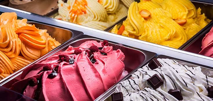 helado de sabor fresa con toppings en charola exhibidora para una heladeria exitosa