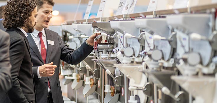 vendedor mostrando a cliente máquinas para hacer helados