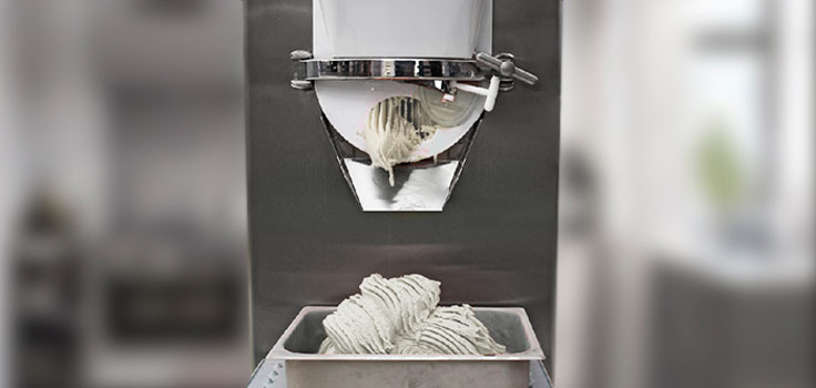 máquina para hacer helado sirviendo helado de vainilla en recipiente de aluminio
