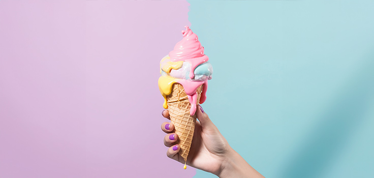 <img src”fotografia-helado-sobre-fondo-de-pared-colorida.png” alt=”Fotografía de un helado que tiene de fondo la pared colorida de una heladería moderna.”>